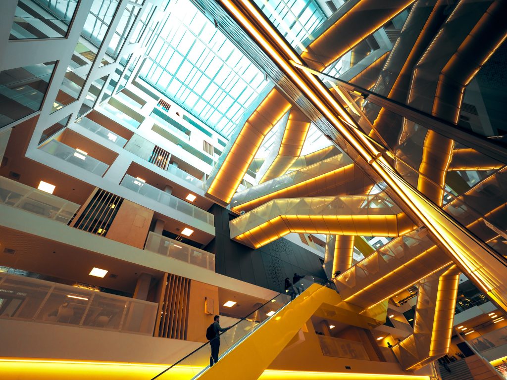 Modern interieur van een onderwijsgebouw met opvallende architectuur en roltrappen